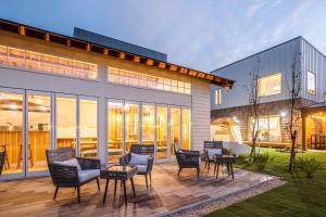 a patio with chairs and tables in front of a building at NAGAHAMA lifestyle glamping hotel in Nagahama