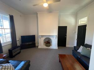 a living room with a couch and a fireplace at The Bolt Inn in Uralla