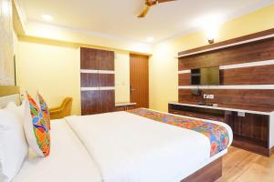 a bedroom with a white bed and a television at FabHotel Prime Signature Inn in Bangalore