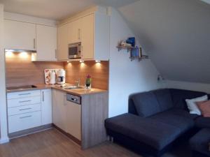 a small kitchen with a couch in a small room at Flotsam and jetsam Modern retreat in Kühlungsborn