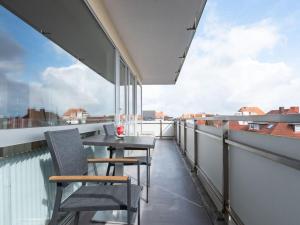 a balcony with a table and chairs on a roof at Haus Seeluft Apartment 32 in Wangerooge