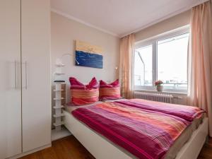 a bedroom with a large bed and a window at Haus Seeluft Apartment 32 in Wangerooge