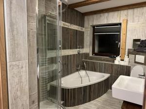 un bagno con doccia, vasca e lavandino di Pure Mountain Partenkirchen NEU seit 2024 a Garmisch-Partenkirchen Altre 46 foto