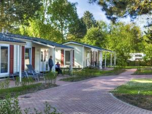 a man standing in front of a house at Mobile home Chatel 'Hotelzimmer' in Fehmarn