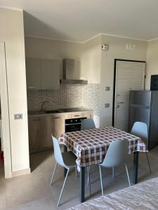 a kitchen with a table and chairs and a refrigerator at Residence 3 Oblò in Giulianova