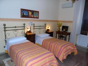 パレルモにあるAlbergo Cavourのベッドルーム1室(ベッド2台、テーブル2台、テレビ付) +16枚の写真