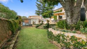 a yard with a house and a tree at Alton House By Wine Coast Holidays in Port Willunga