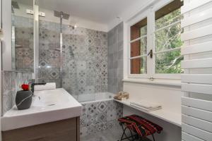 Chalet Ecureuil - Happy Rentals في شامونيه مون بلان: حمام مع حوض ونافذة