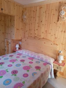 una camera da letto con un letto con copriletto floreale di La Casa dei Nonni a Barrea
