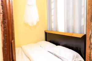 a bed with a wooden head board and a window at Studio Apartment, Kisii in Kisii
