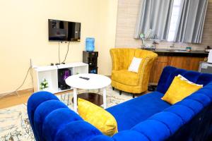 a living room with a blue couch and two chairs at Studio Apartment, Kisii in Kisii