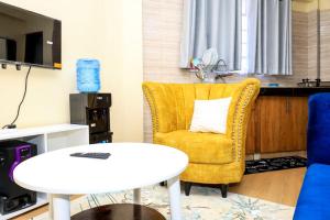 a living room with a yellow chair and a table at Studio Apartment, Kisii in Kisii