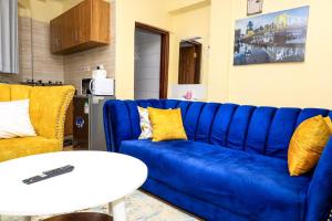 a living room with a blue couch and a table at Studio Apartment, Kisii in Kisii