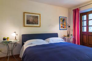 una camera con letto blu, tavolo e finestra di Casa Marta a Pescaglia