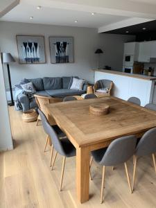 a living room with a wooden table and chairs at La Musardiere in La Baule