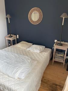 a bedroom with two beds and a mirror on the wall at La Musardiere in La Baule