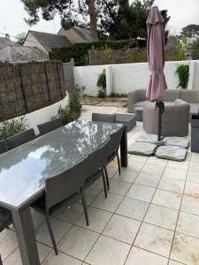 a patio with a table and an umbrella and chairs at La Musardiere in La Baule