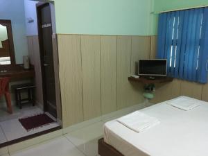 a bedroom with a bed and a tv and a mirror at VALLI HOTEL in Thanjāvūr