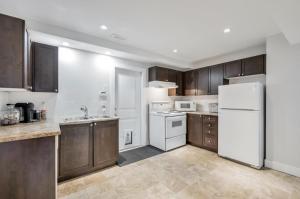 a kitchen with wooden cabinets and a white refrigerator at Private 1 bedroom in Brookswood in Langley