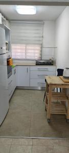 Una cocina o cocineta en דירה פרטית מהממת מוארת. ממוזגת מרוהטת ומקסימה