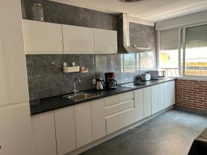 a kitchen with white cabinets and a sink at Gandia Borjia in Gandía