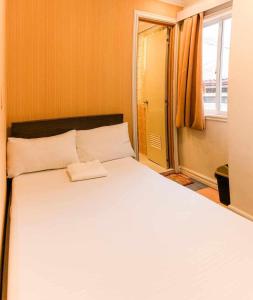 マニラにあるRedDoorz at Emperor Manila Boutique Hotelの窓のある部屋にある大きな白いベッド