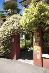 a building with a sign on it next to trees at Atika & Atif - Antica Villa Graziella Venice in Marghera