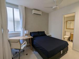 Un dormitorio con una cama y un escritorio y una ventana. en 2Qtos, Botafogo Beach, Botafogo Mall, Modern & Chic, en Río de Janeiro