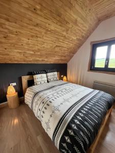 a bedroom with a large bed with a wooden ceiling at Refuge de la banne in Murat-le-Quaire +13 photos