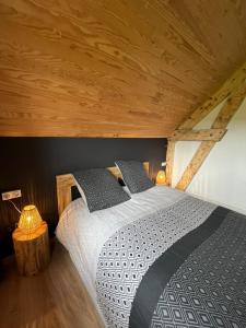 a bed in a room with a wooden ceiling at Refuge de la banne in Murat-le-Quaire
