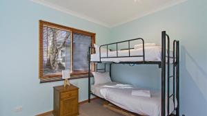 a bedroom with two bunk beds and a window at Secret Hut in Dinner Plain