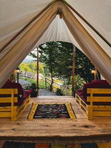 a tent with two beds and a rug in it at Green Hill Lodge in Porumbacu de Sus