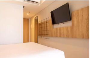 a bedroom with a bed and a flat screen tv at Anagata Tanjung Benoa Bali in Nusa Dua