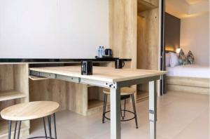 a desk with stools in a room with a bed at Anagata Tanjung Benoa Bali in Nusa Dua