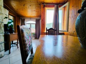 a dining room with a wooden table and a window at Apartman J&F in Smokvica