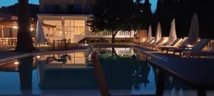 a swimming pool with lounge chairs and umbrellas at Blue Bay Hotel in Iraklitsa