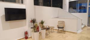 a living room with chairs and plants and a tv at Blue Bay Hotel in Iraklitsa