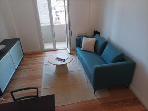 a living room with a blue couch and a table at Lago d'Orta attico Sofia in Omegna
