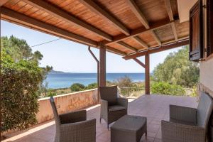 a patio with chairs and a view of the ocean at Villa Esclusiva sul Mare in Custonaci
