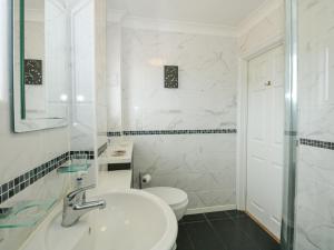 a white bathroom with a sink and a toilet at Potter's Retreat in Dersingham +33 photos