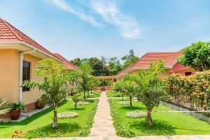 a garden in front of a house with trees at Lindrin lodge moshi in Shiri
