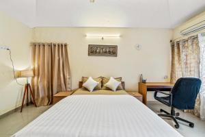 班加罗尔Emerald - Vintage Haven的一间卧室，配有一张床、一张桌子和一把椅子