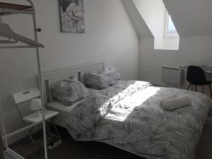 Raon-lʼÉtapeにあるUne étape à Raonの白いベッドルーム(ベッド1台、棚付)