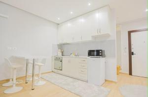 a kitchen with white cabinets and a table in it at Ambient Apartaments in Durrës
