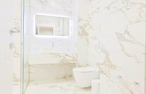 a white bathroom with a toilet and a shower at Ambient Apartaments in Durrës