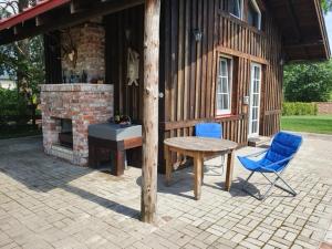 a patio with a fireplace and a table and chairs at Auci Guest house 2 in Liepāja +2 photos