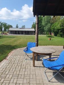 three blue chairs and a table and a table and chairs at Auci Guest house 2 in Liepāja