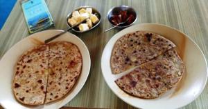 two slices of pizza in white bowls on a table at Pangong Pearl in Man