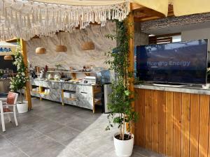 a restaurant with a counter and a kitchen with plants at Ilio Boutique Hotel in Ksamil