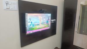 a flat screen tv hanging on a wall at Paradise Homestay - Lodging and Boarding in Pune +20 photos